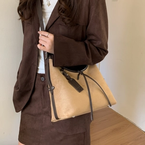 Detail of khaki frosted tote bag with dark brown leather trim and metallic feet
