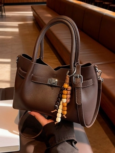 Sac seau en cuir grainé marron foncé avec fermoir rotatif argenté et breloque vintage