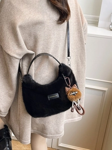 Black faux fur hobo bag with teddy bear charm and love every day tag shown on model