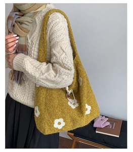 Detail of yellow plush tote bag with white flower embroidery and wooden closure