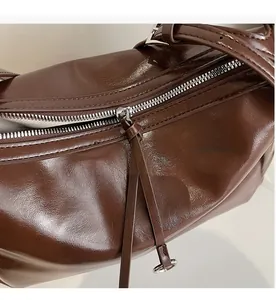 Detail of vintage dark brown tote with smooth silver metal zipper and oil-wax leather texture