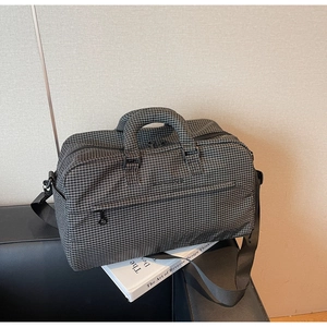 Details der karierten Reisetasche mit verstärkten Griffen und verstellbarem Gurt