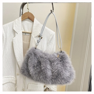 Detailed view of gray faux fur shoulder bag texture with slim leather strap on a metal rack
