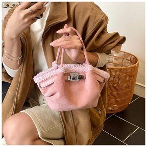 Detail of pink faux suede tote bag with fur trim and silver turn-lock closure