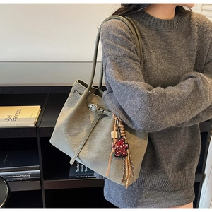 Olive green faux leather tote bag with red leopard bear pendant shown on model