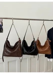 Détail de trois sacs cabas souples avec glands en perles de bois et couleurs classiques