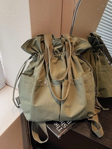 Olive green canvas bucket bag with drawstring and multiple utility pockets