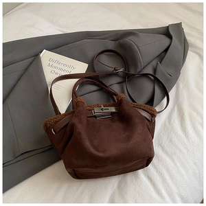 Detail of dark brown suede bucket bag with faux fur trim and silver metal clasp closure