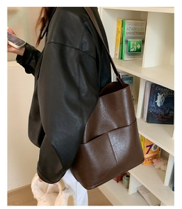 Gros plan sur un sac seau vintage marron foncé avec textures de cuir naturel