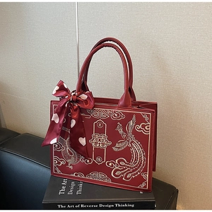 Detail of red Chinese wedding bag with golden dragon embroidery and silk scarf handle