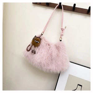 Detailed view of pink faux fur shoulder bag with cute brown plush charm on a wooden hook