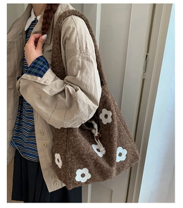 Detail of plush tote bag with flower embroidery and drawstring wooden buckle closer