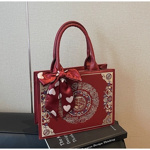 Close-up of Chinese bridal tote bag with golden dragon embroidery and Double Happiness symbol
