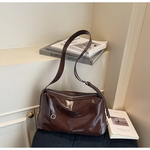 Detail of dark brown oil-wax leather tote with silver zipper and long pullers