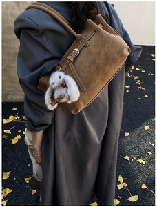 Brown suede shoulder bag with gold metal buckle and cute white plush bunny charm