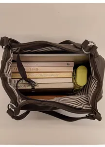 Macro shot showing large capacity interior with striped lining and zipper pocket for storage