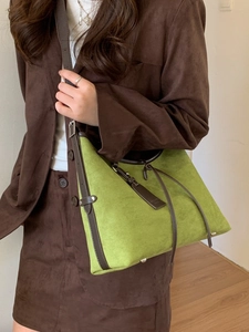 Retro oversized green suede hobo bag with brown leather straps shown on a model