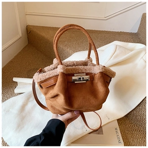 Detail view of winter suede tote bag in caramel with plush trim and metallic buckle closure