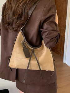 Vintage brown suede hobo bag with fringe detail and contrasting leather piping trim