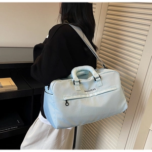Detail der hellblauen Reisetasche mit Webstruktur und verstellbarem Schultergurt