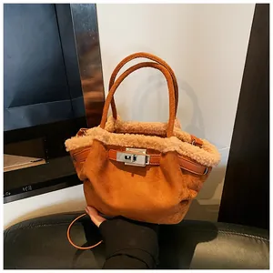 Close-up of caramel suede tote with faux fur trim and silver metallic twist lock closure