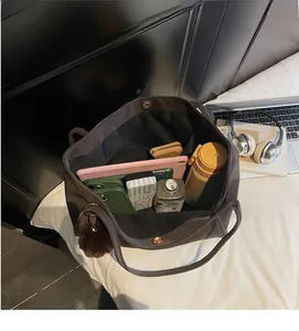 Detailed view of the large capacity interior of a dark brown tote bag with magnetic clasp