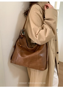 Détail d'un sac cabas en cuir marron avec cordon de perles en bois et texture vintage