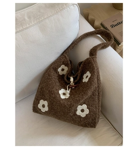 Close-up of brown plush tote bag with flower embroidery and horn button closure