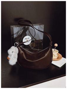 Detail of dark brown hobo bag with silver zipper and a cute grey plush bunny pendant