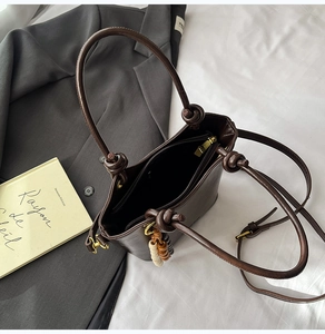 Top view of deep brown bucket bag interior with zipper pocket and knotted handle