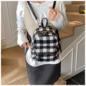 Close-up of checkered plaid mini backpack with plush fabric and gold-tone zippers