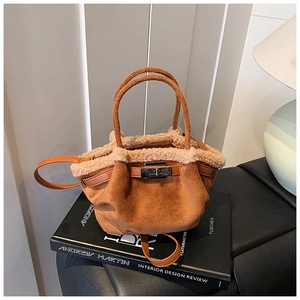 Close-up of caramel suede tote bag with white faux fur trim and metallic buckle closure