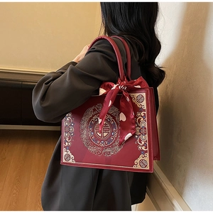 Detail of red bridal handbag with phoenix embroidery and stylish polka dot scarf wrap