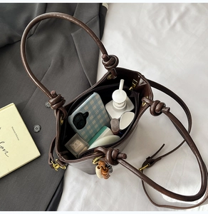 Macro view of dark brown leather bucket bag interior showing spacious storage for essentials