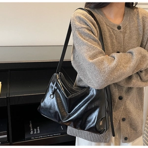 Chic black glossy tote bag styled on model for urban commuting and office wear