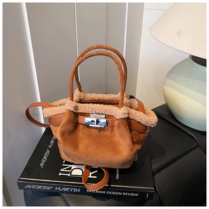 Detail of brown faux suede tote bag with cream fleece trim and silver twist lock closure