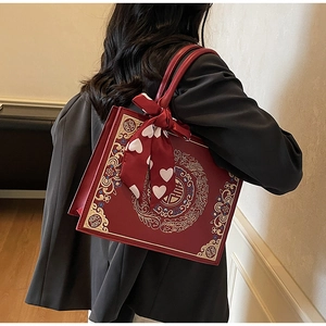 Detail of red bridal handbag featuring traditional Chinese embroidery and silk scarf