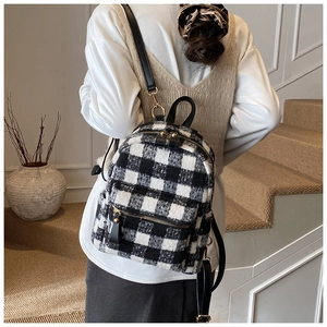 Detail view of the black and white plaid wool backpack showing back straps and texture