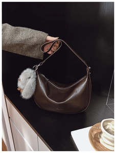 Detailed view of deep brown hobo bag with smooth leather finish and cute bunny pendant