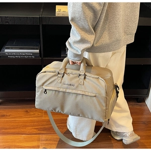 Detail der karierten Reisetasche mit verstärktem Griff und verstellbarem Schultergurt