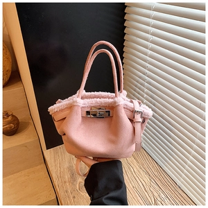 Detail of pink faux suede tote with plush fur trim and silver metallic turn-lock closure
