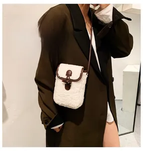 Close-up of lamb wool crossbody bag with brown leather trim and toggle closure