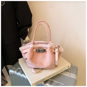 Detail of pink faux suede tote bag with plush shearling trim and silver metal twist lock
