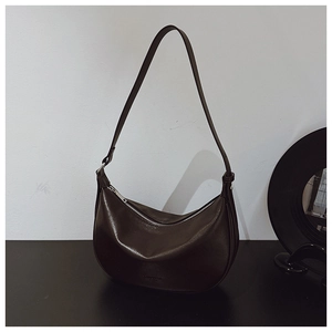 Detail of dark brown matte PU leather crescent bag with zipper and silver buckles