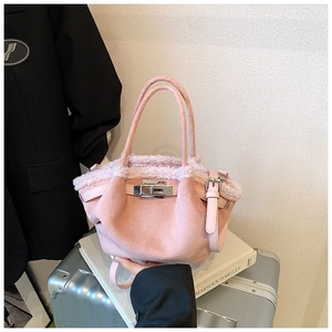Close-up of pink faux suede tote bag with fur trim, metal lock and leather strap detail