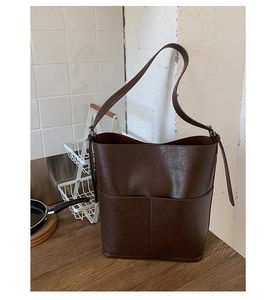 Détail du sac seau marron café vintage avec couture centrale et bandoulière en cuir