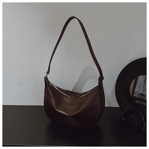 Deep brown half-moon hobo bag detail with smooth matte finish and silver zipper closure