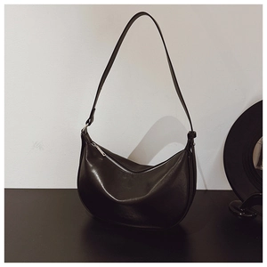Detail of a black crescent moon bag with silver zipper and adjustable thin shoulder strap