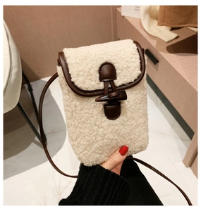 Detail of plush crossbody bag with creamy faux fur texture and brown leather trim