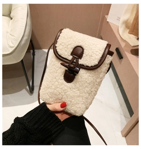 Detailed view of sherpa fleece crossbody bag featuring leather trim and horn button closure